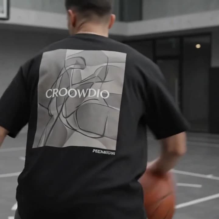 A man turning away, the printed panel on the back of his black tee filling the frame.